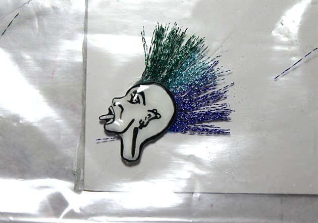 Metallic threads in three different colors are used to create the mohawk. Attach using glue.