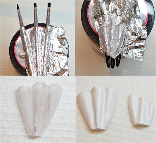 When I did my research, the first thing that caught my eyes where the large wavy dresses so I started by trying to create something that would draw your mind to that. After a lot of failed tries using only tinfoil and pressing it to the shape I wanted, using clay, etc I found that this way worked the best. I attached three brushes with some blu tack and pressed down some tinfoil over it. Then I sculpted the scape using acrylic and then painted it white (using acrylic paint). I then repeated this one more time, only making it smaller.