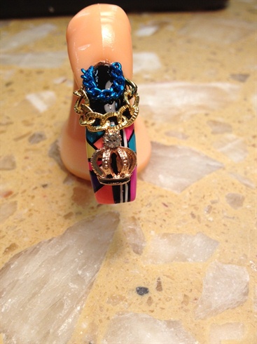 Apply a few drops of nail glue to the chains and charm piece, allowing glue to dry for three to five minutes. Finish desired look with clear polish or gel top coat.
