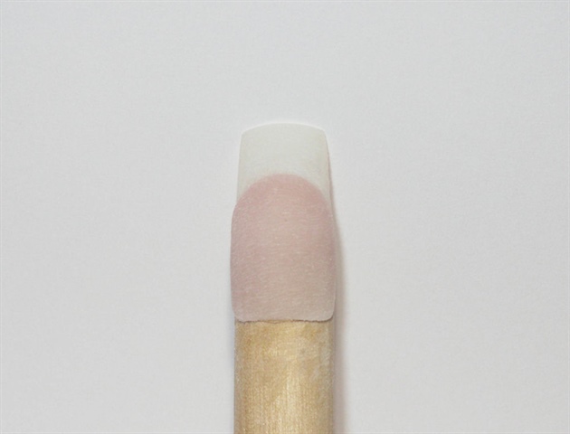Your first step would be to prep the natural nail for acrylic application.  Use a cover nude powder to create the nail bed.  Be sure to shape your smile line in so you can easily move onto the next step.  For an added clarity to the line, file the smile into shape.  