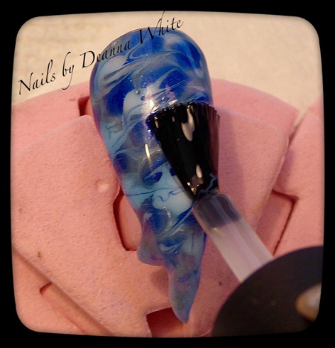 Paint on  a layer of translucent blue gel polish. Full cure.
