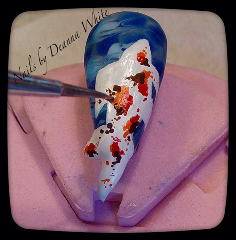 Wipe off dispersion layer. With a small dotting tool and acrylic paint, make orange splotches and dots. Repeat process with red and dark brown. Let paint dry in between colors. 