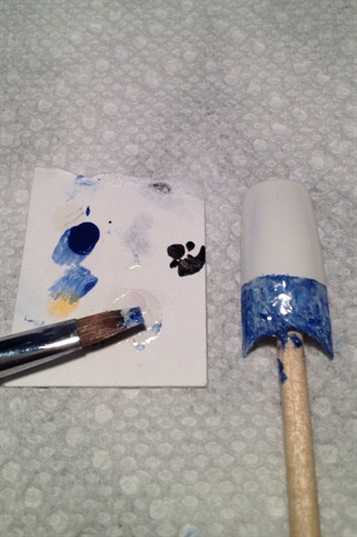 Using a stiff, slanted brush, paint and blend white polish into the royal blue polish while it is still wet. 