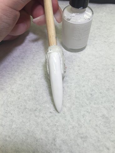 Here, I used a dragon lady stiletto tip. Once dragon lady tip has been sculpted, polished with white. All nails were polished to desired color, in my case, white and black for the base and background color of this challenge.