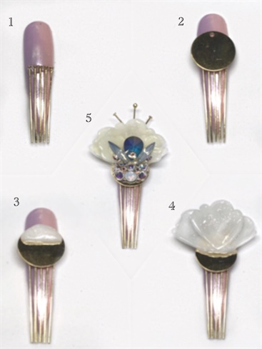 1. Apply a band of Bling On across the nail and evenly place gold headpins to resemble a hairpin, cure.\n2. Place a bead of Bling On and secure a gold disc, cure.\n3. Sculpt a half circle at the top of the disc, the petals will be cured into it.\n4. Place the petals in a fan shape into the uncured gel, cure.\n5. Add the two smaller petals on top of another bead of the Gel Art Powder mixture, cure. Lightly brush on a wash of Peaceful to the petals, cure. Topcoat with Shine On, cure. Embellish with various sizes of Swarovski Crystals, and add 3 headpins to the top with Bling On, cure.\n