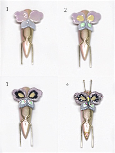 1. Paint top wings with Lilac Flourish, and bottom wings with Berry Elegance, cure.\n2. Add Peaceful and Wink inside the wings, cure.\n3. Outline Peaceful with Black Paint, adding curves to mimick the shape of the wing. Outline Wink with White Paint and add a dor of Strawberry Cream to each bottom wing, cure.\n4. Stroke lightly through the top wings with White Paint. Outline cuticle area and add a diamond hape to the tip, cure. Topcoat with Shine On, cure. Embellish with small Swarovski crystals, and add 2 headpins as antennae with Bling On, cure.
