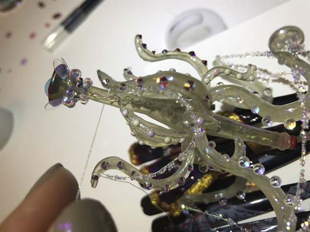 Crystal pixie strings were wrapped around the tentacles and glued. And then using scissors or nipper to cut the remaining strings before adding last pieces of swarovski crystals as finishing touch. 