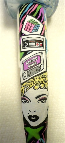 This photo is a close up of the rubix cube, cassette tape ( with madonnas name), the Nintendo controller and Madonnas face.  At this point I desided to paint over the music notes and I did so with black polish