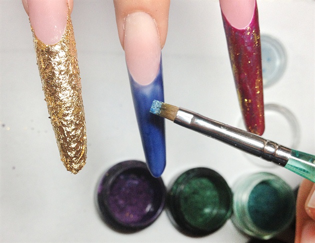 Apply royal blue, emerald green, and deep magenta on the pinkie, middle, and pointer finger, respectfully. Use mica powder, like eye make up, to lightly dust the sticky gel after being cured. Finish off with a gold mica powder to complete the silky fabric effect.