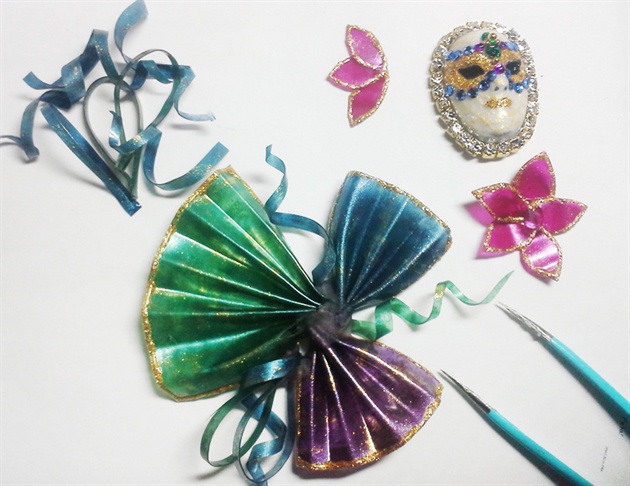 Arrange and attach gel fans and ribbons with acrylic. Then attach the mask and flowers with acrylic.