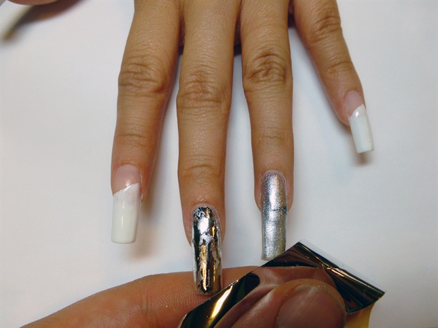 Apply white gel diagonally across the Thumb, Pointer and Pinkie fingers. Paint a metallic silver gel over the Middle and Ring fingers and apply transfer foil after curing.