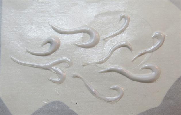On non stick paper,  marble white and clear gel and create several curly lines to resemble smoke.