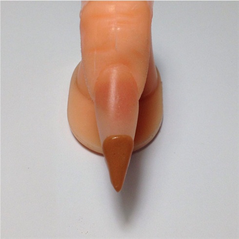 With the nail already buffed and cleaned off for nail art, apply a large bead of light brown acrylic to the bottom third of the nail. Make sure to spread the acrylic neatly and cover the corners of the nail to create the cone.
