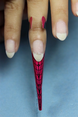 Prep the nail for acrylic application. Apply your forms to all nails. Since these will be almond shaped, remember to slightly angle your form downwards so the nails appear straight instead of growing upwards.