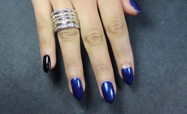 I applied a shimmery midnight blue polish to most of the nails and added a few black accent nails. Leave one nail with a nude half moon. 