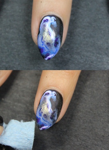 For the black nails, place a few drops of water onto the nail and then swirl in different colored paints. I used blue, purple, white, and gold. Take the corner of a paper towel and soak up some of the excess liquid.