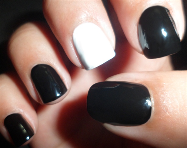 Apply Base coat to protect your natural nails then paint all your nails black except for the middle finger, paint it white.