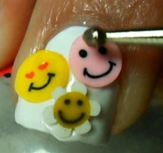 For the middle finger nail, apply smile and happy fimos, as many as you wish.