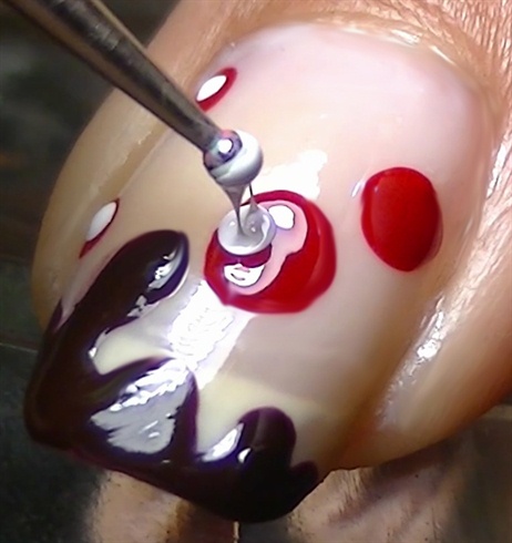 Using a smaller dotting tool, create white dots inside of the red ones