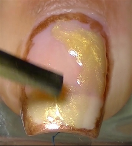 Using yellow gold nail polish paint randomly leaving gaps