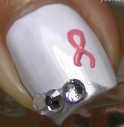 Draw a pink ribbon using acrylic paint and a fine brush