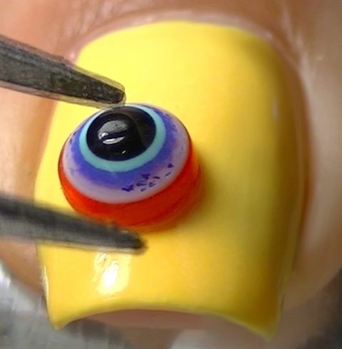 Apply a 3D eye using nail glue or clear polish
