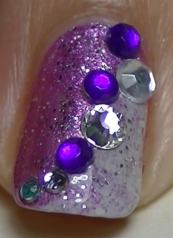 On the accent nail, add a layer of top coat and while is wet, apply rhinestones.