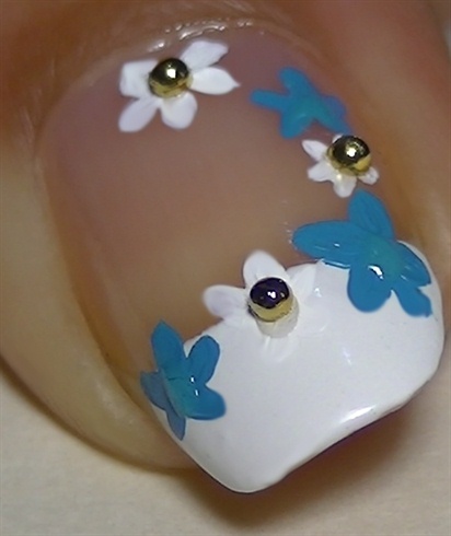 Add clear polish over the white flowers center and apply golden beads