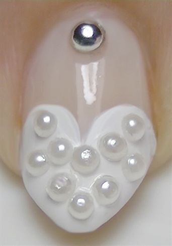 Using clear polish to act as glue, place white half pearls all over the heart