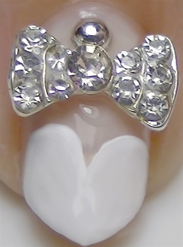 On the accent nail, place a cute  3D rhinestones bow using nail glue