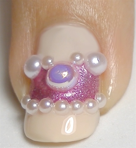 For the rest of the nails, add a layer of a non-fast dry top coat, start placing pearls and rhinestones as shown