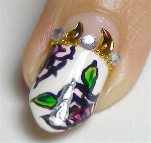 Add a layer of top coat to act as glue and place rhinestones and micro beads to complete this manicure