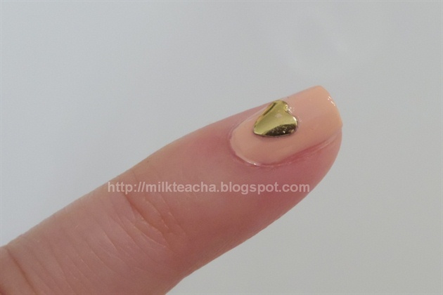 Put a tiny drop of clear polish in the center of the pinky. Use a stick or tooth pick to set the stud on it.