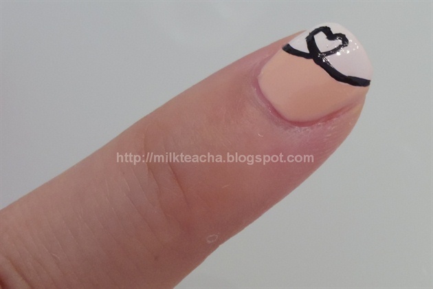 Use a nail art liner or nail art pen with black polish to draw a loop with a heart on the index finger.
