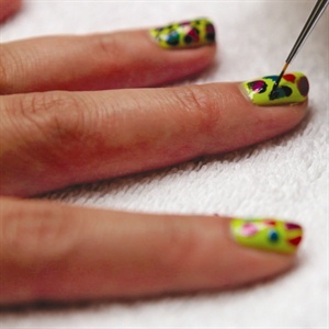Taking a darker opaque shade, frame the individual spots on each side with imperfect lines and shapes. A skinny nail art brush is best but toothpicks and eyeliner brushes also make great tools.