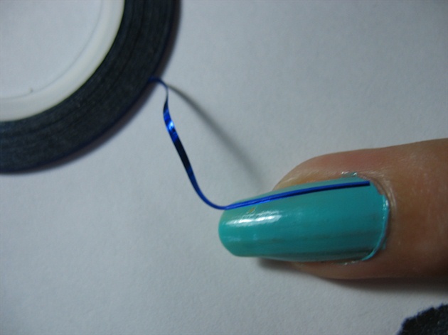 Lay the tape slowly in a straight line to the farthest part on your nail. Avoid any kinks or dents as they will lift off all your work. Cut off the extra bit carefully.