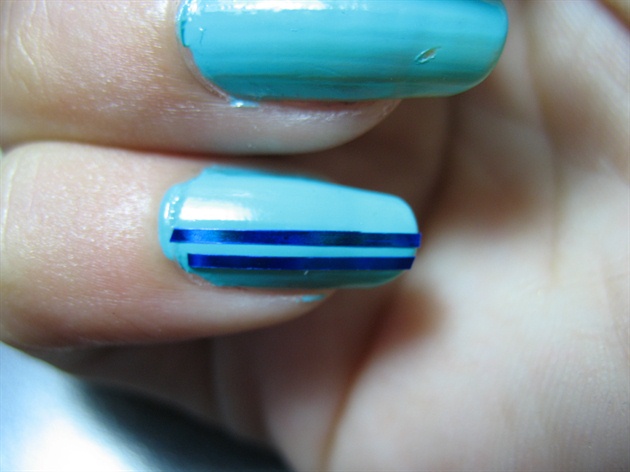 Apply a second strip parallel to the first one. Be careful to keep the spacing even as otherwise it will show any imperfections in the straightness of  your line.  A finished nail should look like this. Apply a generous top coat to keep the tape in place.