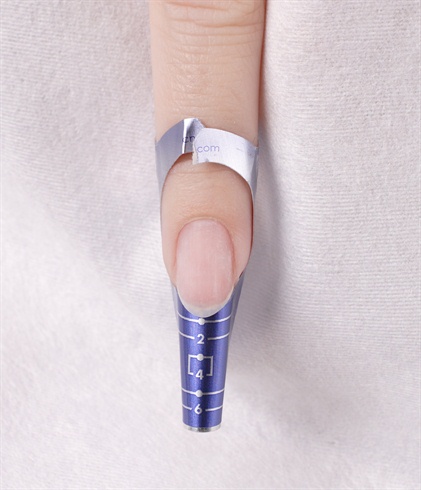Tear the back of the form to allow proper movement when fitting the form underneath extension edge of the natural nail.