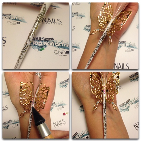 Making golden image - drawing patterns using special black gel for foil, curing it for 2 mins and then stamping a foil on it. Attaching wings to the nail using drops of clear acrylic. Adding a lot of crystals to the design.