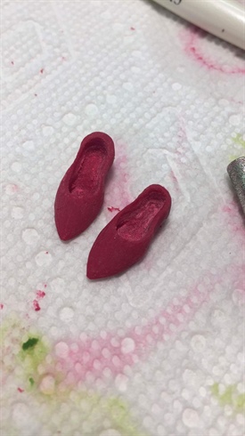 I sculpted the slippers from acrylic. Once they had set, I did some refining work with my e-file.\nI used Scarlett Crystals to make them into Ruby Slippers, these nails wouldn’t be complete without them!