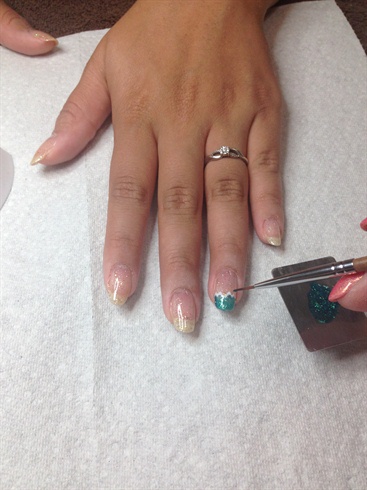 I chose to apply a sheer gold glitter as my base color to add a little Hollywood glitz. I then used white gel to outline my French tip, and filled it with teal glitter on the accent nail. This pulls in the teal from the El Capitan beautifully.