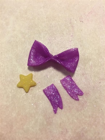 4) Separately make the two ribbons that go under the bow and the star for the center of the bow. Assemble on hat and add Swarovski pixie to star for extra pizazz.
