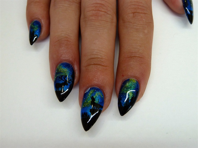 Using black gel polish, I applied the base of my design and cured between layers.\nI removed the dispersion layer and began painting on my silhouette with black acrylic paint. \nI chose to paint some tall pine trees on each of the five nails along with an elk, a teepee, a whale tail with dripping water, some distant mountains and a wolf on top of a cliff howling at the moon. The moon was created using some watered down white acrylic paint. Once again using a water color method, I waited for it to semi dry and then using a dry brush, I lightly touched it to absorb the excess paint. I finished my design with some tiny dots of white acrylic paint to mimic stars. Once dry, I applied a glossy top coat gel polish and cured.