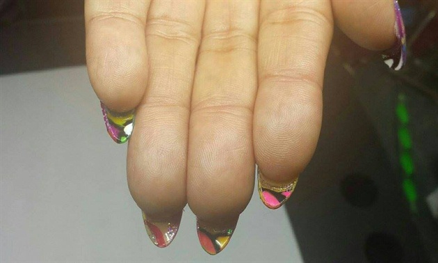 On the back of the nails, add more color and shapes and outline with black. 